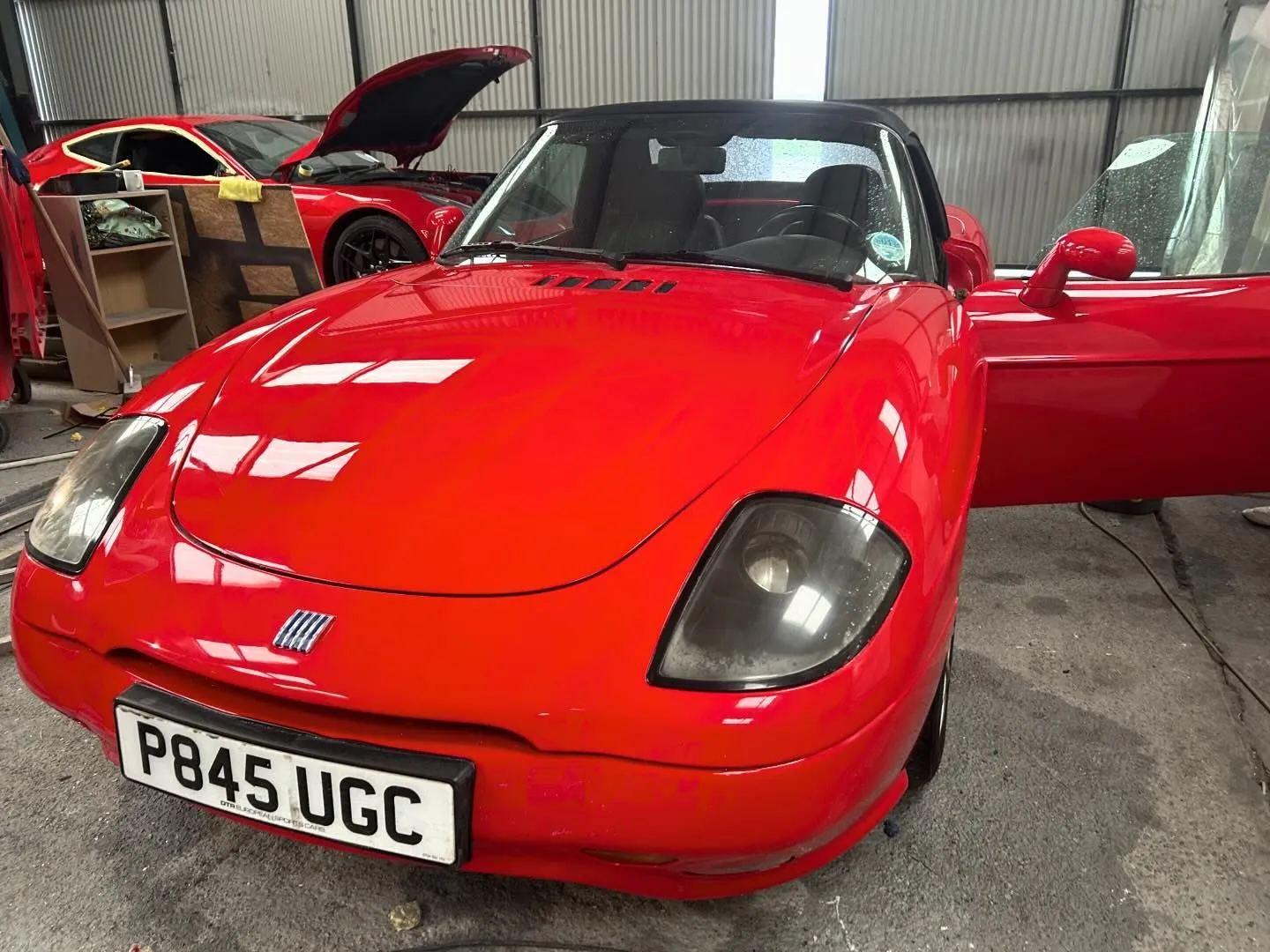 A red sports car parked in a garage.