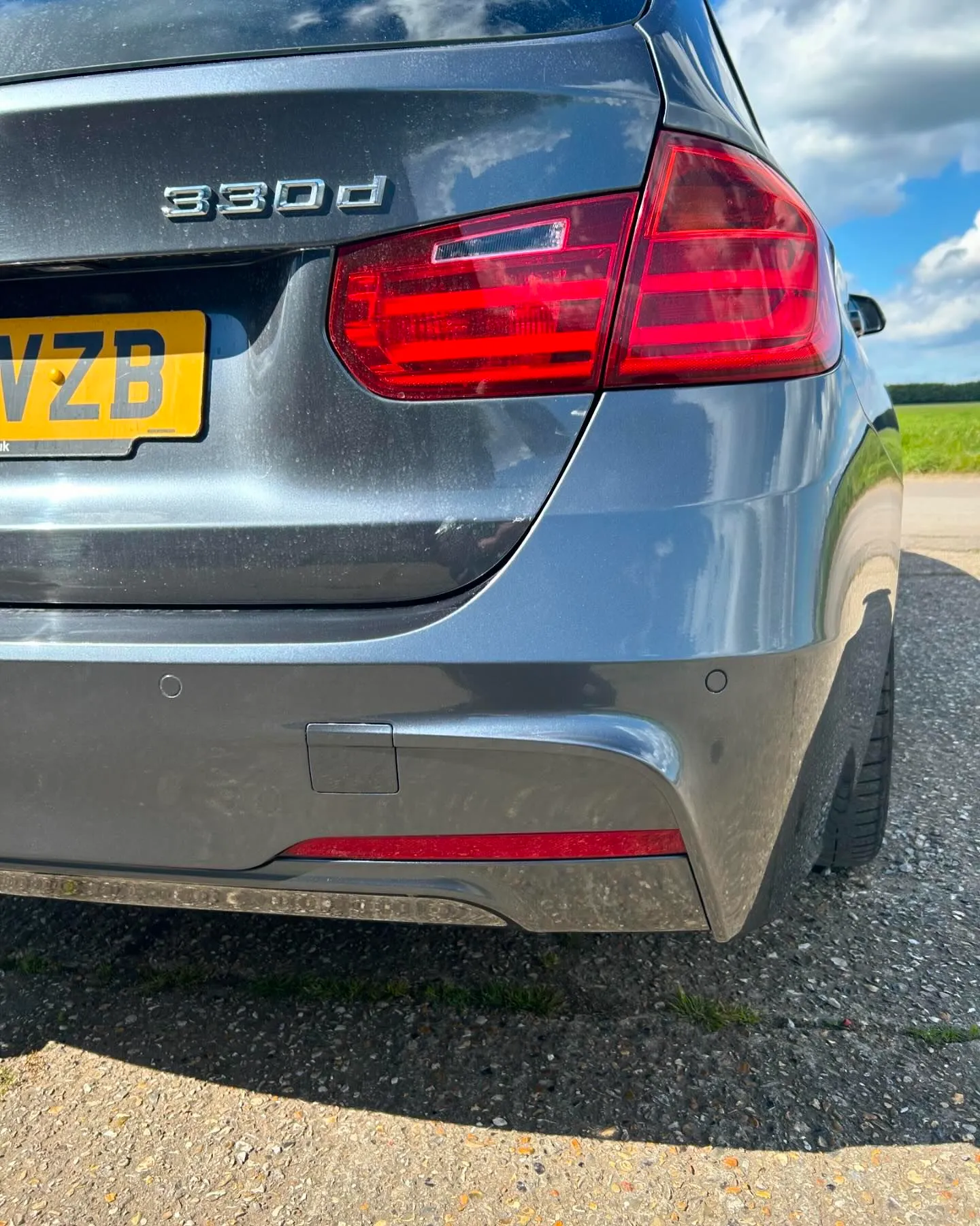 A grey car parked on the side of the road.