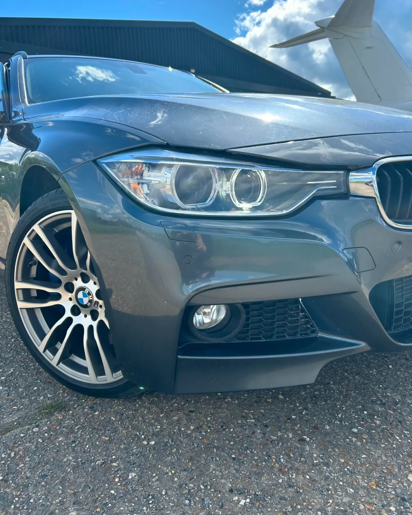A grey car parked in front of a building.