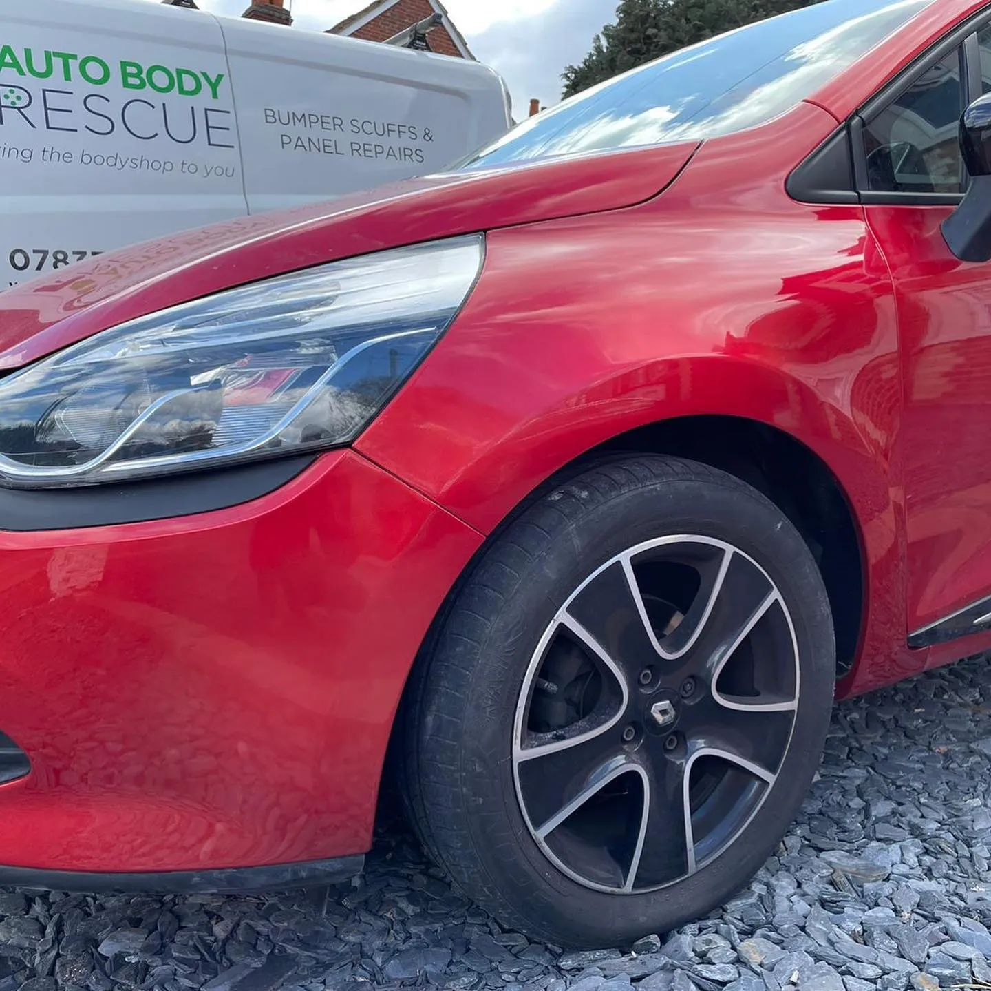 A red car parked next to a white truck.