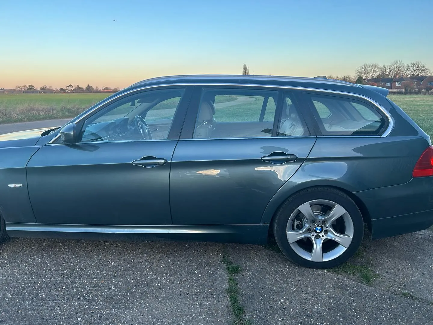 A grey car parked on the side of the road.