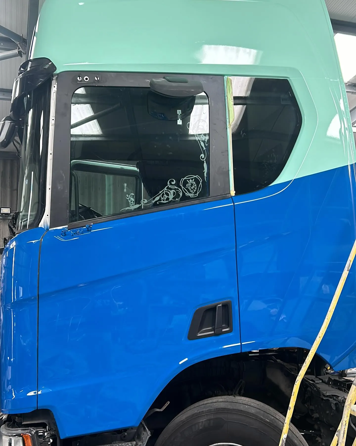 A large blue truck parked inside of a garage.