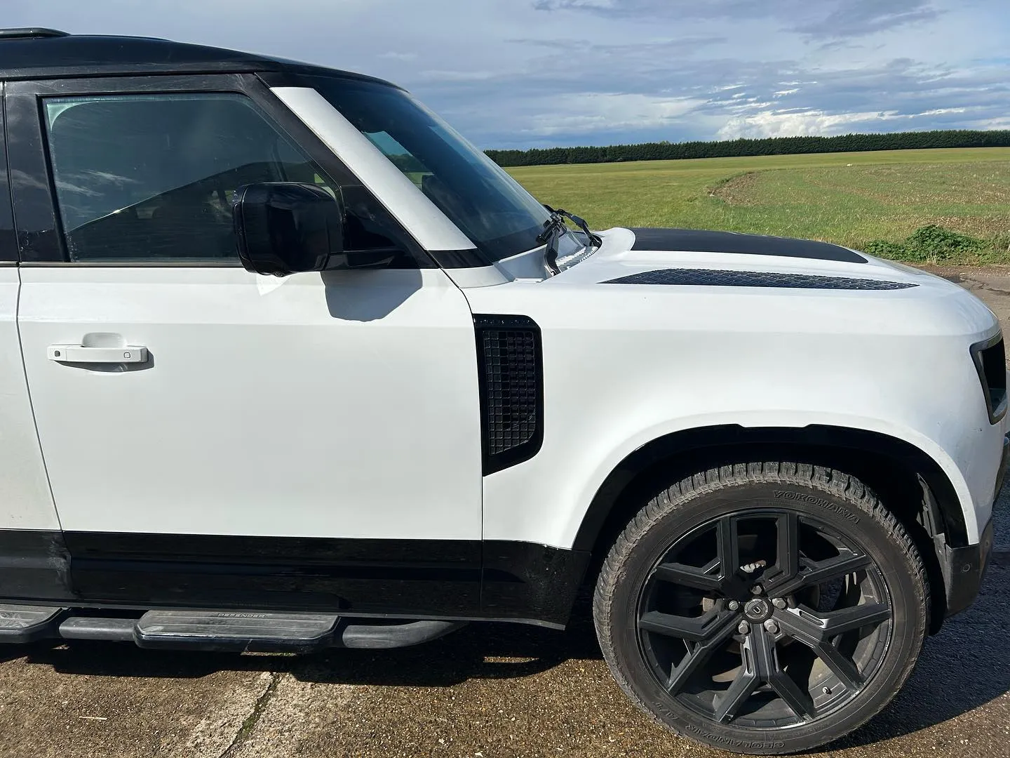 A white suv parked on the side of a road.