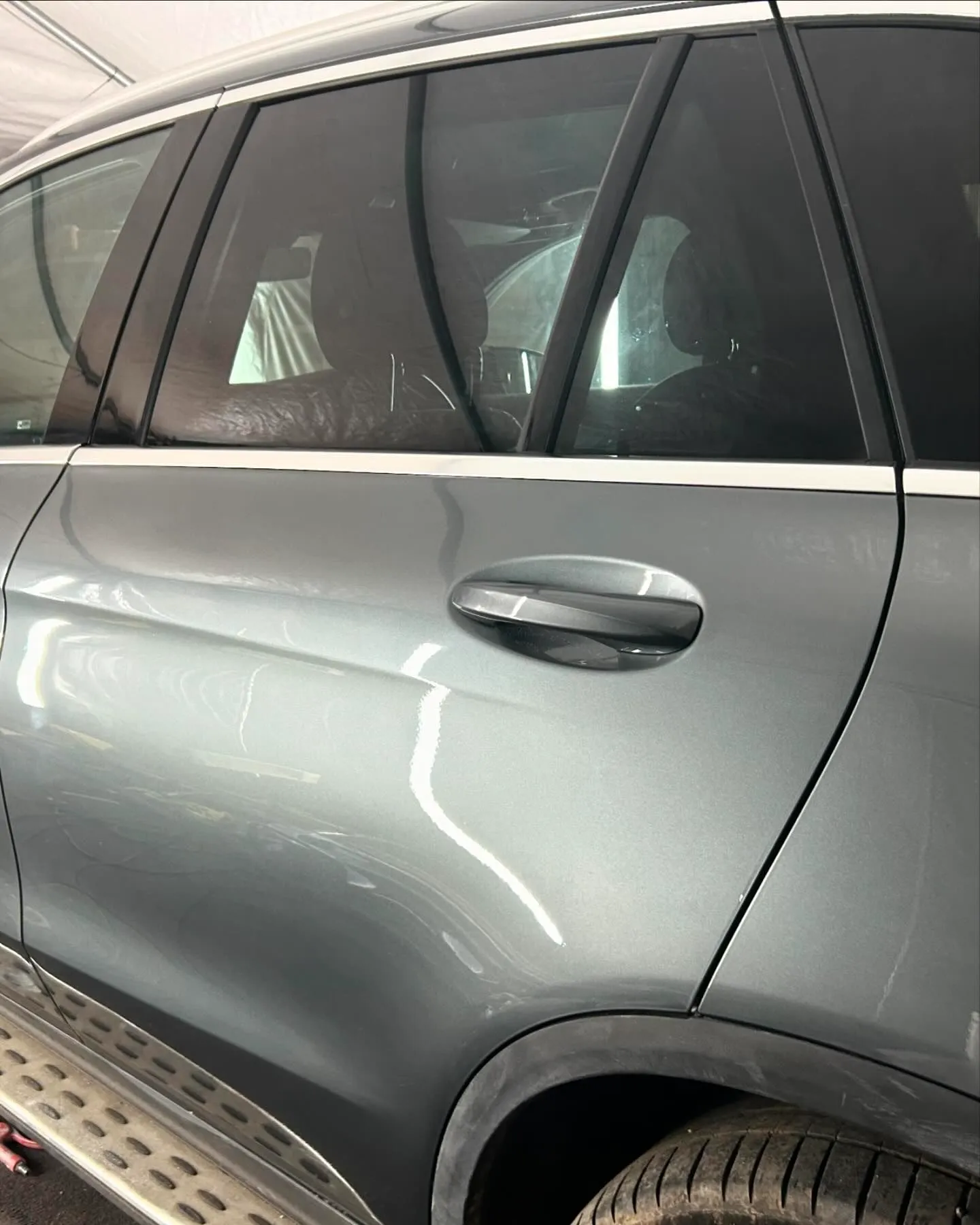 A grey car parked inside of a garage.