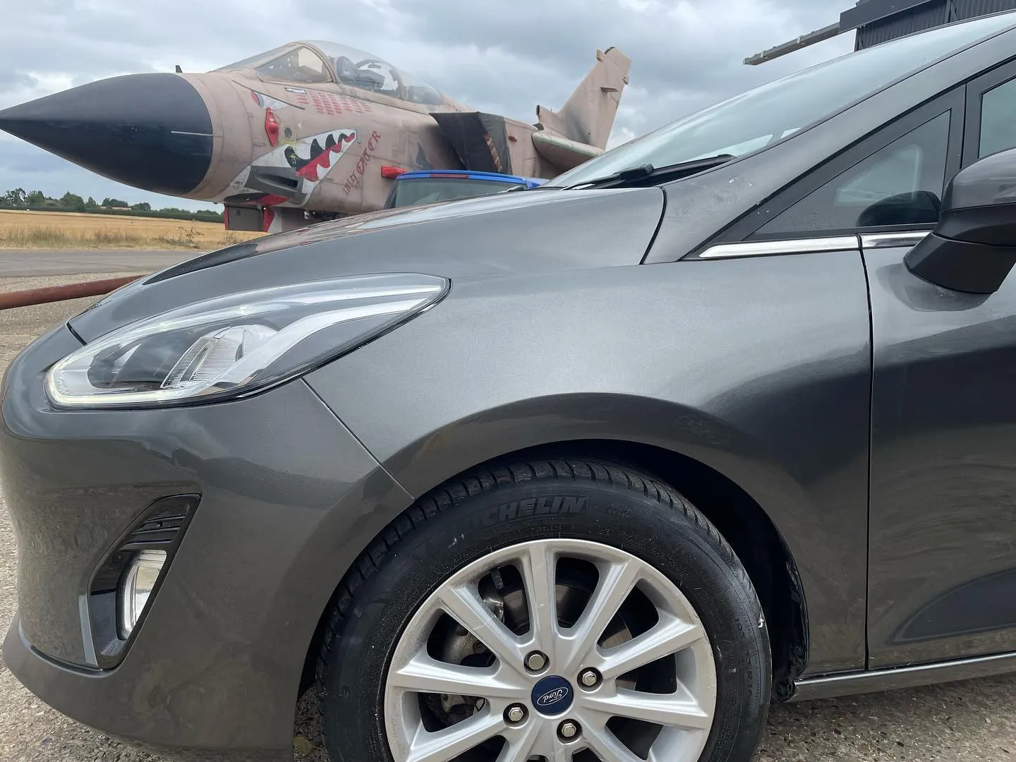 A grey car parked in a parking lot.