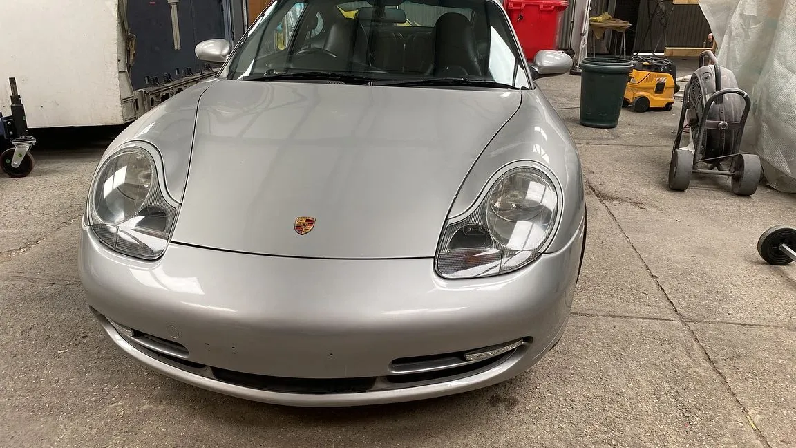 A silver sports car parked in a garage.