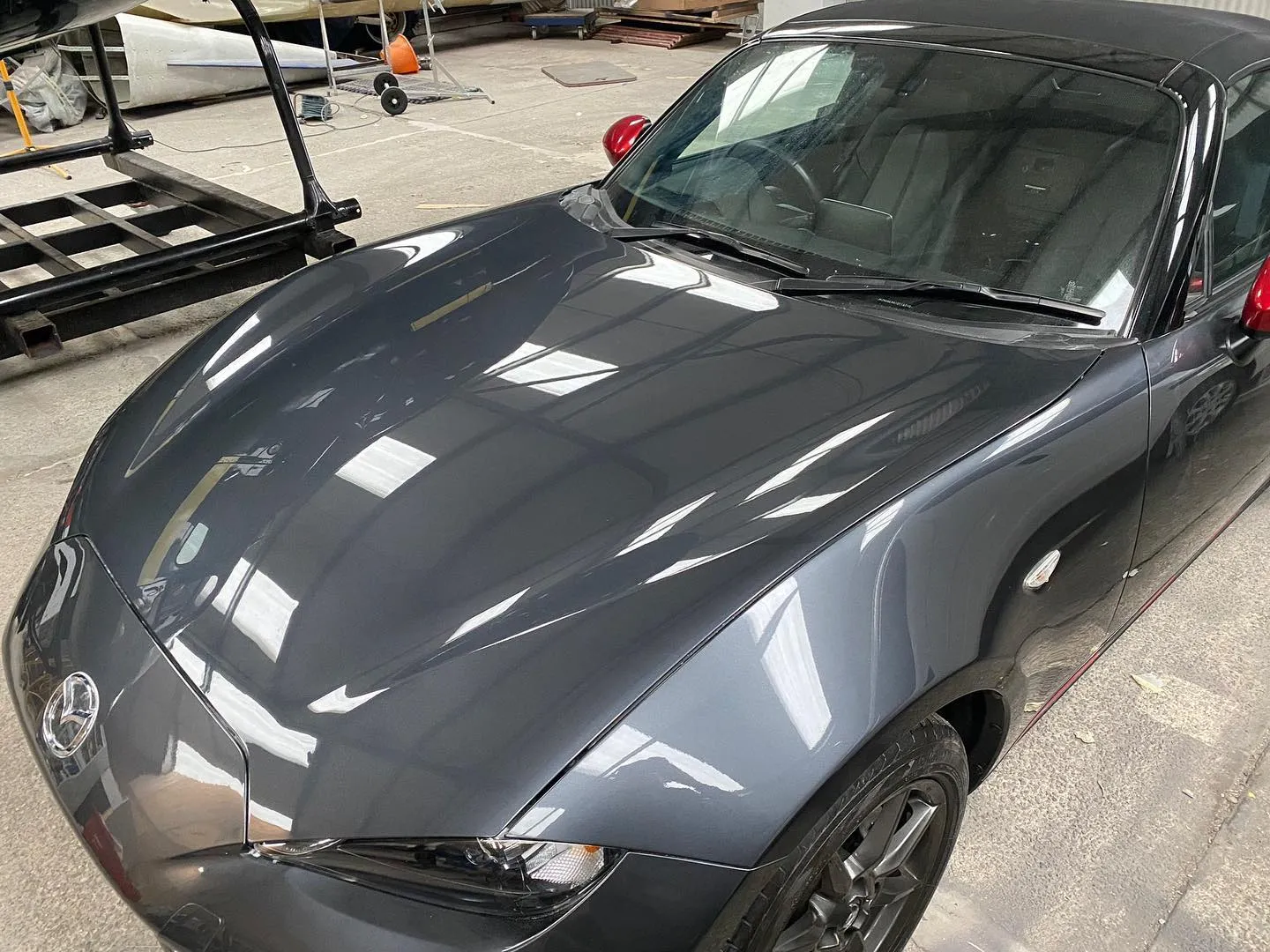 A gray sports car parked in a parking lot.